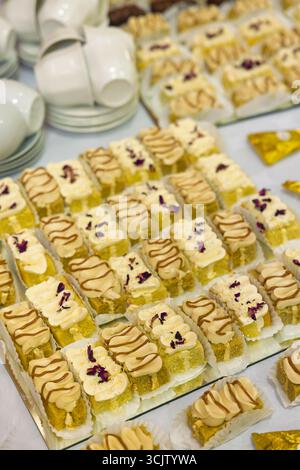 biscoff fetta di torta al caramello alla vaniglia, dessert shoot bites bar, sul tavolo, tazze di tè e caffè sullo sfondo, evento Foto Stock