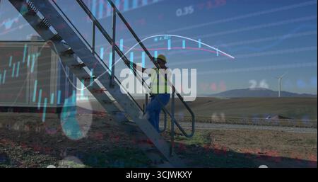 Tecnico sul campo che indossa elmetto giallo, giubbotto per salire le scale nel parco eolico, con copertura finanziaria Foto Stock