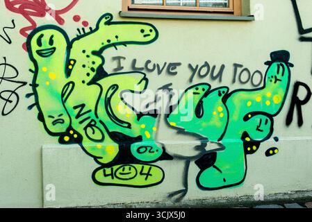 Un pezzo colorato e stravagante di graffiti su un muro urbano nel quartiere storico di Rixdorf, Berlino, Germania. La Street art presenta un gruppo Foto Stock