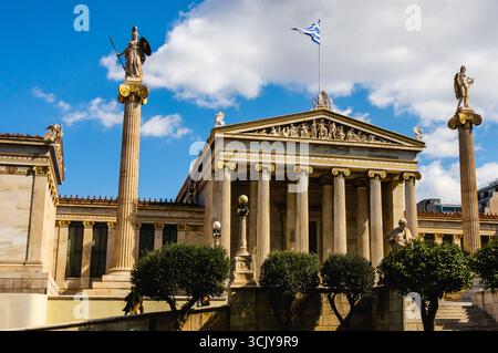 Accademia di Atene punto di riferimento neoclassico con statue e bandiera in Grecia. Foto Stock