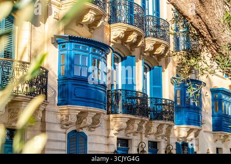 Strada con splendide case storiche con colorati balconi in legno a la Valletta, capitale di Malta Foto Stock