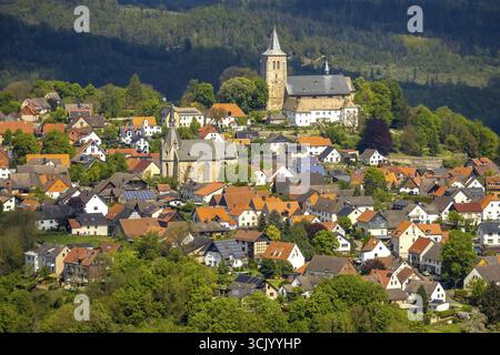 Vista aerea, zona residenziale vista locale Obermarsberg su una montagna boscosa, di fronte alla chiesa cattolica romana St. Nikolaikirche, dietro la chiesa collegiale St. PE Foto Stock