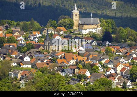 Veduta aerea, area residenziale vista locale Obermarsberg su una collina boscosa, di fronte alla chiesa cattolica romana di San Nicola, dietro la chiesa collegiata di San Pietro Foto Stock