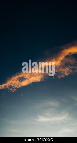 Splendido tramonto che crea una vista estetica in una combinazione di colori rosso, giallo, arancione e motivi che si affacciano sull'oceano, tranquillo e tranquillo Foto Stock