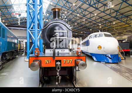 Vista frontale della locomotiva a vapore se&CR Classe D n. 737 accanto a uno Shinkansen, noto anche come Bullet Train, esposta al National Railway Museum di York, Inghilterra Foto Stock