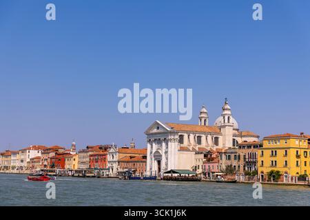 Venezia, Italia, 11 agosto 2025: Colorato canale veneziano con chiesa dei Gesuati Foto Stock