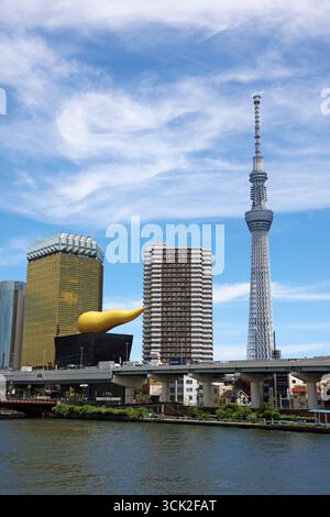 Torre della birra Asahi, sala della birra Asahi e fiamma Asahi con il Tokyo Skytree accanto al fiume Sumida, Sumida, Tokyo, Giappone Foto Stock