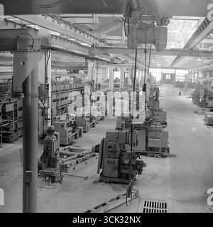 Una vista panoramica di una spaziosa officina meccanica presso lo stabilimento "Slavtyazhmash" di Sloviansk, RSS Ucraina, scattata nel febbraio 1975. La fotografia d'archivio cattura file di torni e fresatrici in perfetto ordine in una sala vuota durante un cambio di turno o un giorno libero. Il telaio trasmette la portata e il potere dell'industria pesante sovietica durante l'era della stagnazione, presentando un paesaggio industriale in cui il soggetto principale è il potenziale produttivo, congelato in previsione di un cambiamento di lavoro Foto Stock