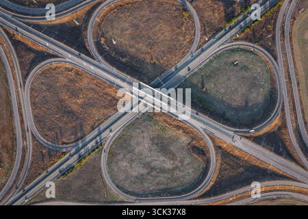 Vista aerea dello splendido incrocio autostradale in forma di trifoglio durante il giorno estivo. Concetto logistico Foto Stock