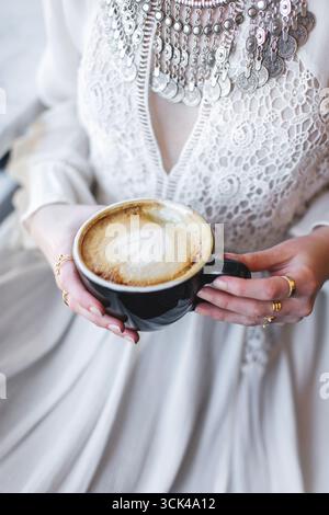Cappuccino con motivo a base di schiuma di latte nelle mani delle donne Foto Stock
