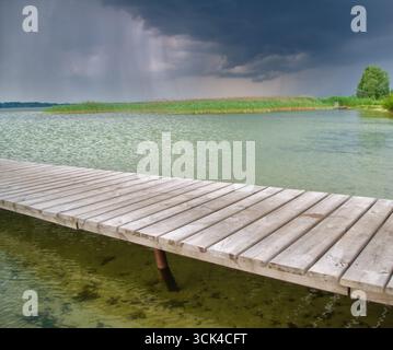 Molo in legno sullo splendido lago. Composizione naturale. Foto Stock