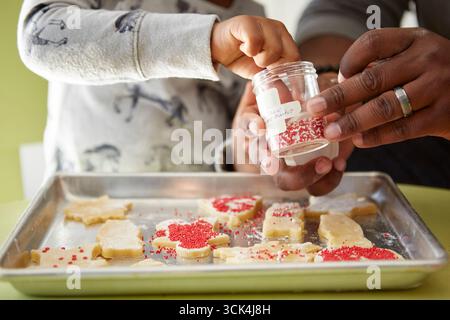 Padre e figlia di decorazione biscotti crudi, close-up Foto Stock