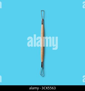 Un utensile a doppia estremità con manico in legno, progettato per attività di scultura o creazione. Foto Stock