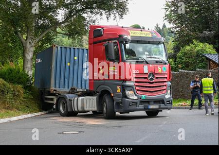 Leisnig - LKW bleibt in enger Kurve auf Johannistalstraße in Leisnig hängen: Feuerwehr zieht LKW aus der Patsche 05.09.2025 gegen 14 Uhr Leipzig, Johannistalstraße/Jahnstraße Wegen der Sperrung der Muldebrücke bei Fischendorf führt der Umleitungsverkehr derzeit auch für Lastwagen durch die Leisniger Innenstadt über die steile Johannistalstraße. AM Donnerstagmittag ist dort gegen 14 Uhr ein ausländischer LKW-Fahrer mit einem Containeraufleger in Schwierigkeiten geraten. Beim Rückwärtsrangieren in einer engen Kurve kam der LKW von der Fahrbahn ab, überfuhr einen Bordstein und blieb im Gebüsch hä Foto Stock