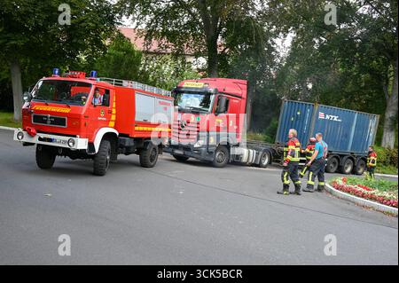 Leisnig - LKW bleibt in enger Kurve auf Johannistalstraße in Leisnig hängen: Feuerwehr zieht LKW aus der Patsche 05.09.2025 gegen 14 Uhr Leipzig, Johannistalstraße/Jahnstraße Wegen der Sperrung der Muldebrücke bei Fischendorf führt der Umleitungsverkehr derzeit auch für Lastwagen durch die Leisniger Innenstadt über die steile Johannistalstraße. AM Donnerstagmittag ist dort gegen 14 Uhr ein ausländischer LKW-Fahrer mit einem Containeraufleger in Schwierigkeiten geraten. Beim Rückwärtsrangieren in einer engen Kurve kam der LKW von der Fahrbahn ab, überfuhr einen Bordstein und blieb im Gebüsch hä Foto Stock