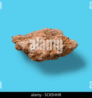 Un pezzo di roccia ruvido e irregolare che mostra texture naturali e colori terrosi. Foto Stock