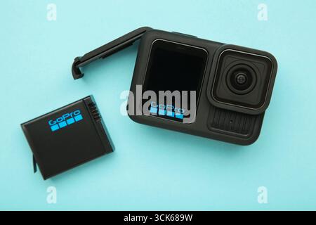 Ucraina, Mykolaiv - 1 settembre 2025: Action camera GoPro 13 e una serie di accessori su sfondo blu. Vista dall'alto Foto Stock