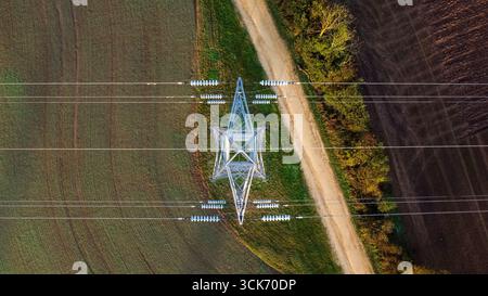 Vista aerea del pilone elettrico e delle linee elettriche sui terreni agricoli Foto Stock