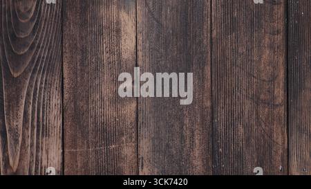 Uno sfondo in legno testurizzato caratterizzato da tonalità scure e ricche, adatto per vari progetti di grafica. Foto Stock