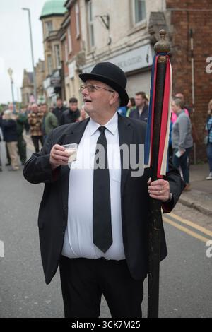 John Newman, il capo alberdiere in cappello da bowler, bevendo la tradizionale bevanda Rowell Fair di rum e latte. La Rowell Charter Fair si svolge il lunedì del proclama. Rothwell, Northamptonshire, Inghilterra giugno 2023 Regno Unito 2020s HOMER SYKES Foto Stock