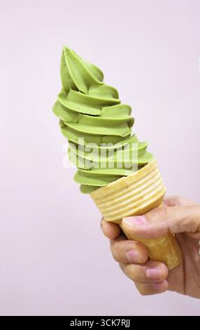 Tenendo a mano un delizioso gelato con tè verde Matcha Foto Stock