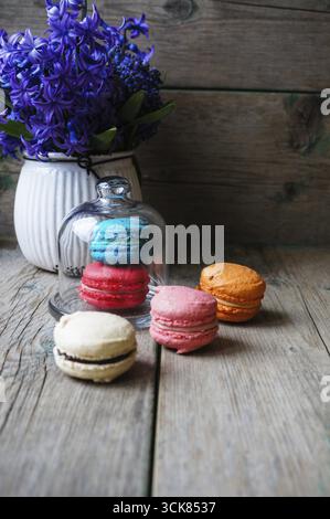 Amaretti colorati sul vecchio sfondo di legno Foto Stock