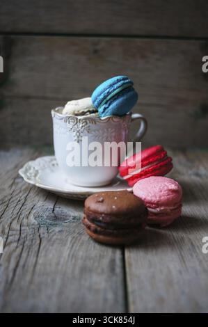 Amaretti colorati sul vecchio sfondo di legno Foto Stock