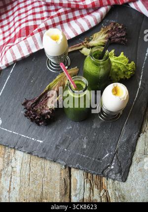 Delizioso frullato di spinaci e uova sode sul tavolo di legno Foto Stock