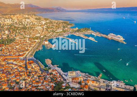 Immagine drone di Spalato che mostra il vivace porto con barche e traghetti, la storica città vecchia con il Palazzo di Diocleziano, gli edifici in pietra e l'Adriatico Foto Stock