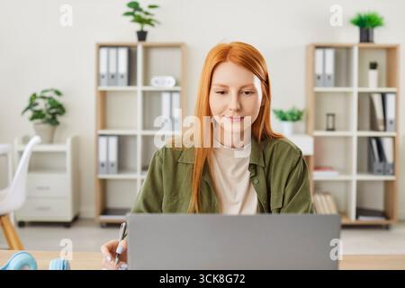 Donna che lavora o studia online a casa con Un notebook sul tavolo Foto Stock