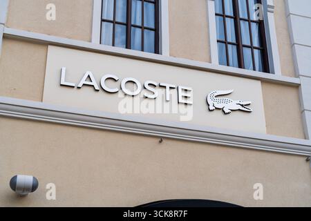 Cannock, Staffordshire, Regno Unito – 9 settembre 2025: Logo di Lacoste, un'azienda globale di abbigliamento sportivo in un negozio outlet Foto Stock