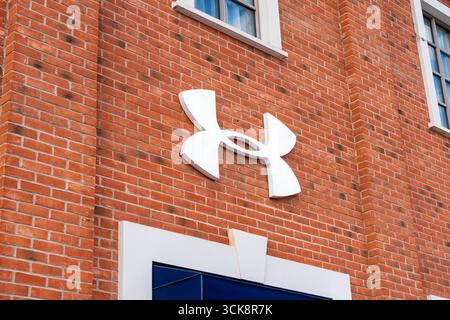 Cannock, Staffordshire, Regno Unito – 9 settembre 2025: Logo di Under Armour, un'azienda di abbigliamento sportivo in un negozio outlet Foto Stock