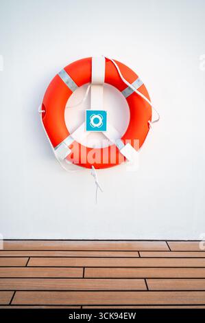 Orange Lifebuoy sulla White Cruise Ship Wall. Foto Stock