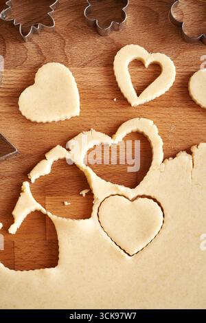 Forma del cuore tagliata dall'impasto per preparare biscotti di Natale fatti in casa con Linzer, vista dall'alto Foto Stock