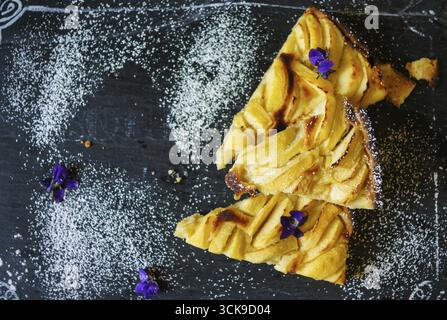 Il francese crostata di mele sul vecchio tavolo rustico con fiori e igienico Foto Stock