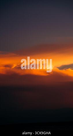 Splendido tramonto che crea una vista estetica in una combinazione di colori rosso, giallo, arancione e motivi che si affacciano sull'oceano, tranquillo e tranquillo Foto Stock