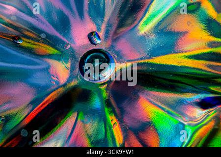 Un vivace primo piano di vetro di cristallo sotto la luce diretta, che mostra rifrazioni radiose e motivi astratti in tonalità rosso, blu, verde, giallo e arancione Foto Stock