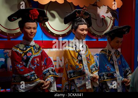 Manichini a grandezza naturale o figure di cera in costumi tradizionali cinesi salutano i clienti in un negozio di Nanluoguxiang Hutong, Pechino, Cina Foto Stock