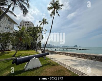 Un cannone nei giardini che indica il mare di fronte all'Eastern & Oriental (e&o) Hotel nella città di Goerge, capitale di Penang, in Malesia, Foto Stock