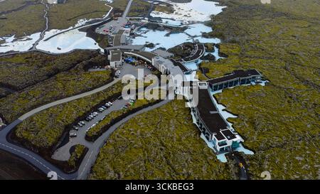 Le terme geotermali della Laguna Blu con acque blu latte, architettura moderna e terreno vulcanico coperto di muschio, catturate da una prospettiva aerea. Foto Stock