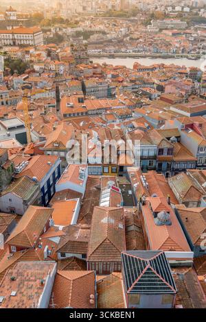Vista aerea dalla Torre dei Clerigos del quartiere di Porto Ribeira e del fiume Douro con tradizionali tetti di mattonelle rosse. Lungomare storico portoghese, Golden Hour Foto Stock