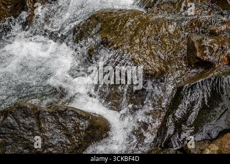 Primo piano di una piccola cascata che cade sulle rocce. Foto Stock