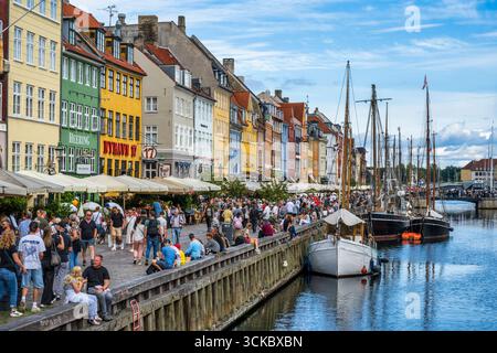 Il lungomare di Nyhavn è fiancheggiato da case cittadine dai colori vivaci del XVII e XVIII secolo, una posizione popolare per i visitatori, nel centro di Copenaghen, Danimarca, Nort Foto Stock