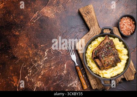 Primo piano di teneri costolette di manzo, splendidamente caramellate e riposate su un letto di cremoso purè di patate, creando un'invitante scena culinaria. marrone Foto Stock