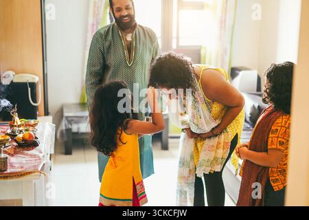 Famiglia indiana che celebra la religione evento indù a casa - Sud Cultura asiatica e concetto di stile di vita - Focus sul volto della donna Foto Stock