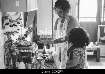 Famiglia indiana che celebra la religione l'evento indù a casa - culture e concetto di stile di vita dell'asia meridionale - Focus su Woman Face - editing in bianco e nero Foto Stock