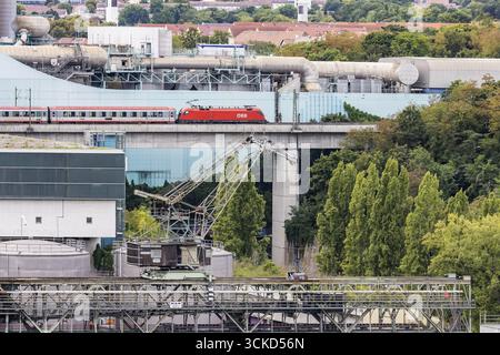 Treno intercity OEBB Austrian Federal Railways che viaggia sulla Schusterbahn, viadotto Muenster con EnBW energie Baden-Wuerttemberg combinando calore e calore Foto Stock