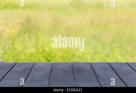 Piano portapaziente con sfondo bokeh astratto sfocato. Piano da tavolo con texture rustica vuoto con sfondo naturale verde sfocato. Mock-up del display per il prodotto Foto Stock