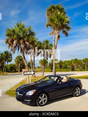 Lussuosa Mercedes-Benz SLK blu decappottabile parcheggiata vicino a palme in una giornata di sole in Florida, Stati Uniti. Foto Stock
