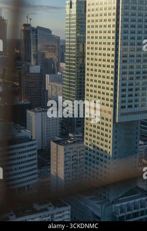 Vista del centro di Varsavia dal Palazzo della Cultura, con grattacieli, un edificio in vetro verde, gru da costruzione e ringhiera in metallo Foto Stock